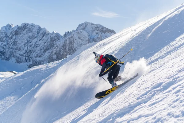 Sciatore in azione su una pista innevata di montagna.